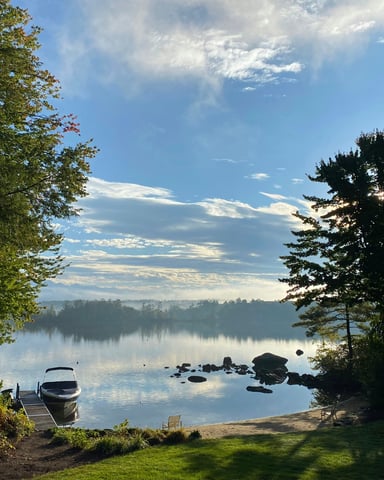 Calm lake with dock, tall trees, and open sky in Washington state